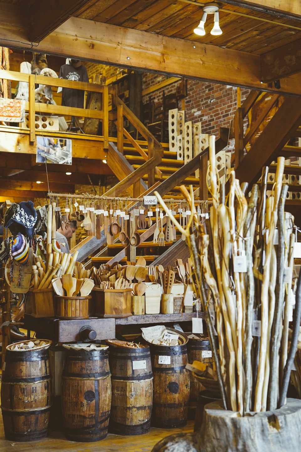 Artisan arranging wooden crafts in a rustic shop.