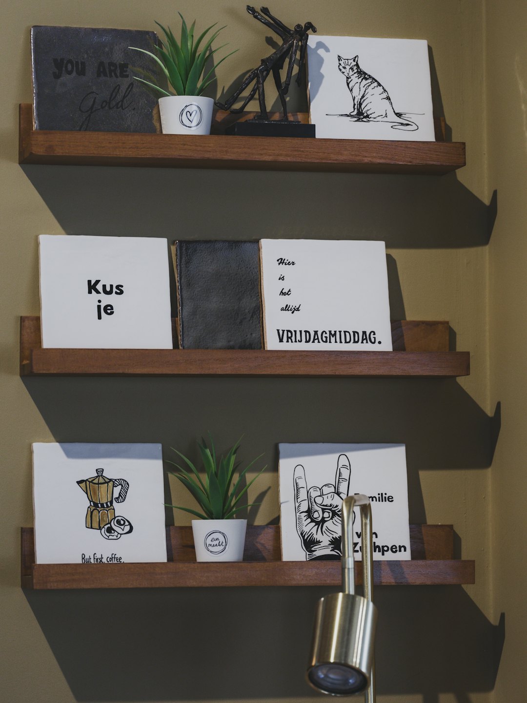Three wooden shelves holding plants and decorative ceramic art.
